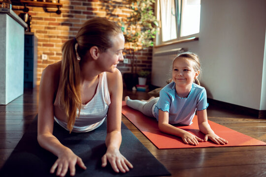 Mother and daughter doing yoga together at home
