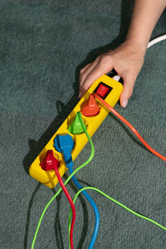 Hand Holding Power Strip with Colorful Cords