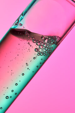 Close up of a test tube with moisturizer on clean pink background. 