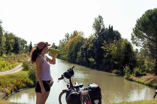 Cyclist drinking by canal