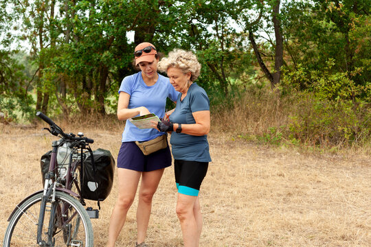 Cyclists Reading a Map Outdoors