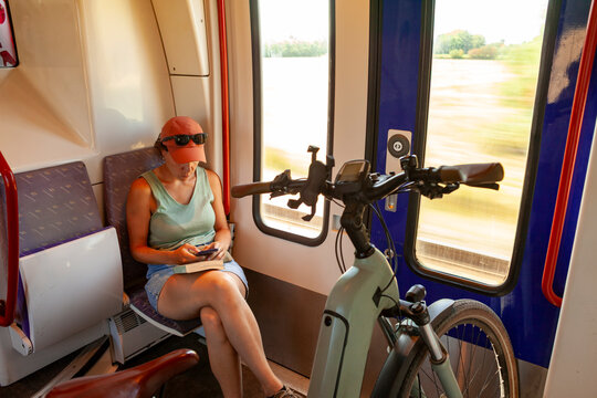 Cyclist Relaxing with Her Bike on a Train