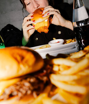 Anonymous girl holding a crispy fried chicken cheese burger