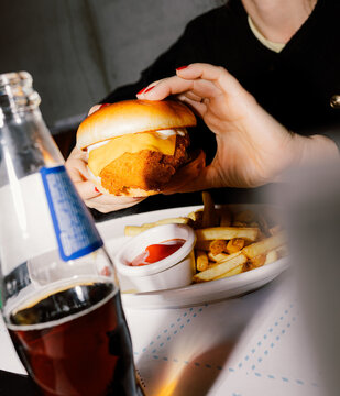 Anonymous girl holding a crispy fried chicken cheese burger