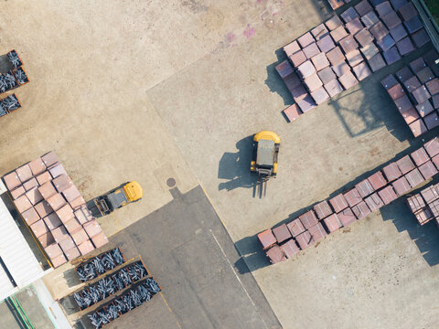 Aerial Logistics Yard with Forklifts Moving Cargo Crates