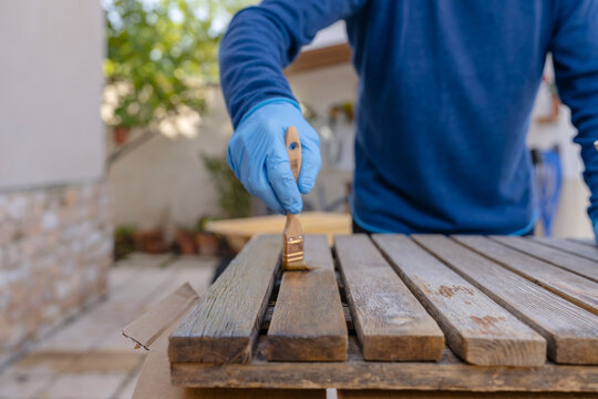 Senior restoring wooden tables