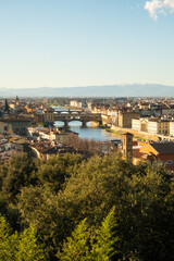 Obraz premium View of Florence city with bridges and buildings along the river at midday in Italy