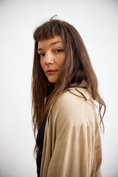 Woman with long hair posing against a plain background