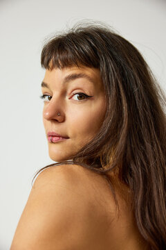 Woman poses with long hair and natural makeup at studio