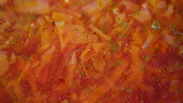 Hearty vegetable soup. Warm hearty borscht with vegetables. Steaming bowl of rich vegetable soup with herbs. Closeup of steaming hearty vegetable soup with herbs and spices