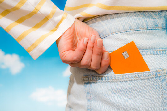 Orange chip card held above denim pocket