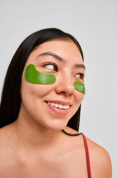 Woman with green eye patches looking aside