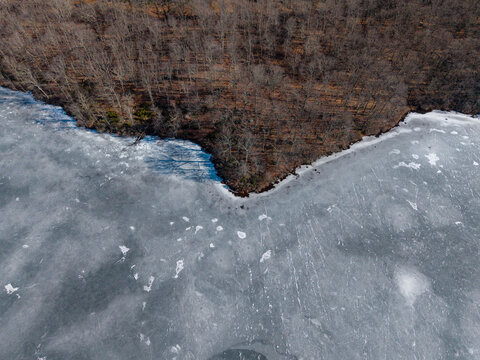 Frozen lake along forested shoreline in winter