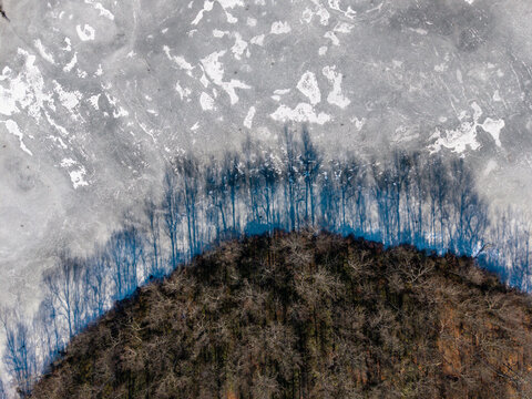 Tree line shadows on frozen lake surface