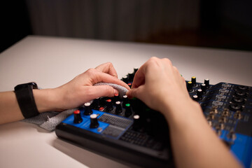 Fototapeta premium Professional cleaning of audio console with soft cloth under warm light. Studio engineer performing routine upkeep on soundboard using gentle motions and accurate wiping