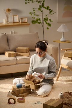 Woman packing a box at home for shipping, online shopping
