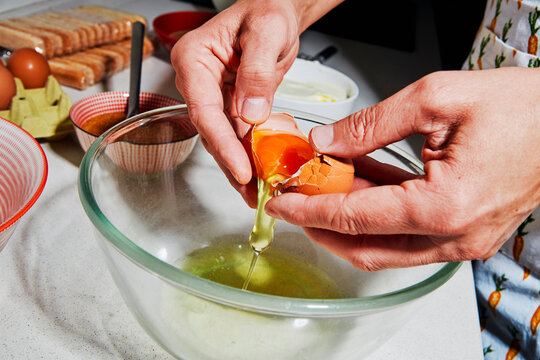 egg yolk passed between shells above a mixing bowl