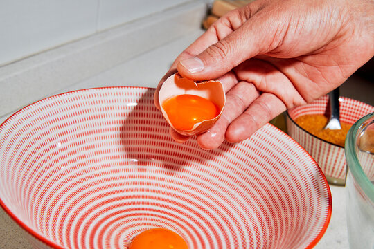 a man transfers egg yolks into a bowl