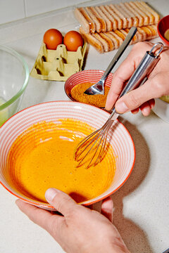 a man whisking egg yolks with sugar in a bowl