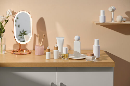 Cosmetic products and accessories on a wooden table in a bright room.