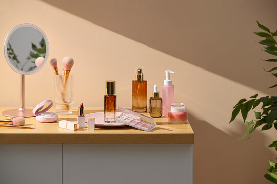 Cosmetics and skincare products arranged on a wooden surface
