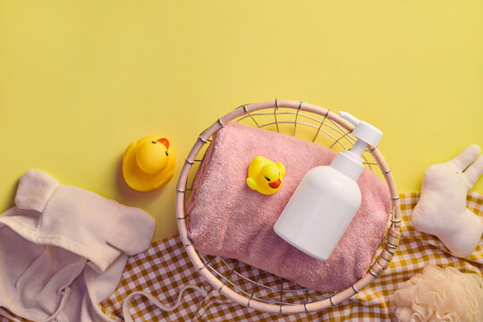 Baby bath time essentials arranged on a yellow background
