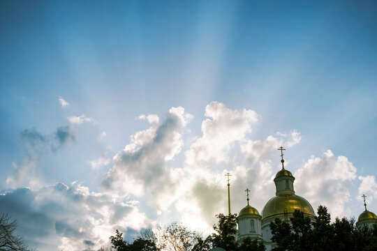 Golden domes shine under the sunset sky.