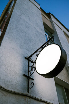Sign hanging on wall in evening light