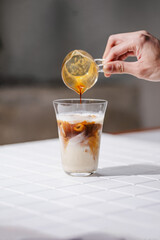 Pouring Fresh Espresso Shot into Iced Milk Glass
