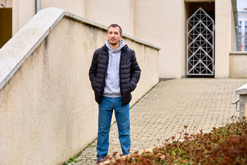 Man stands calmly on a paved path beside a low wall © Iurii Gagarin
