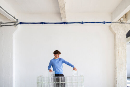 Man Arranges Glass Blocks In Modern Studio