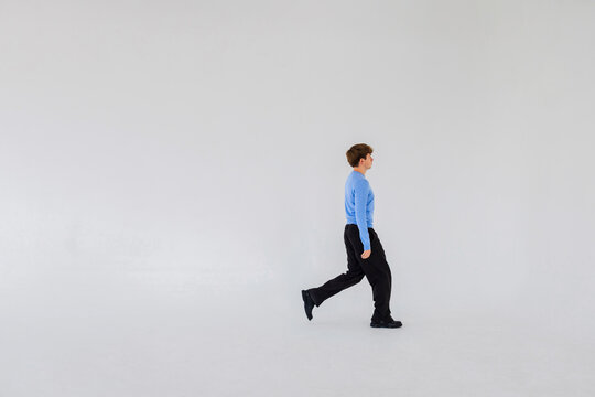 Man Walking In Blue Turtleneck In Studio Setting