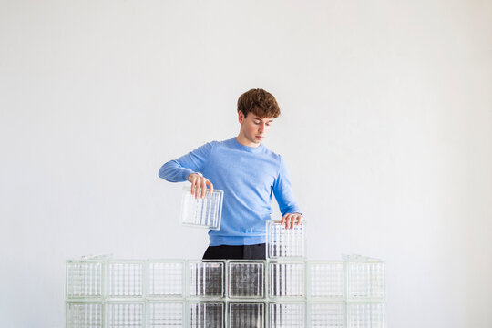 Man Building Glass Wall With Blocks