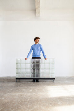 Man With Blue Sweater Behind Glass Block Wall