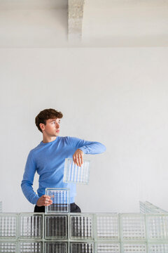 Man Building Glass Block Wall Indoors