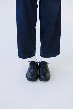 Person Standing In Jeans And Black Dress Shoes