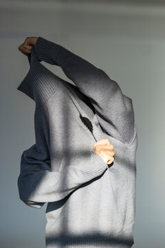 Hiding Behind A Gray Sweater In Silence