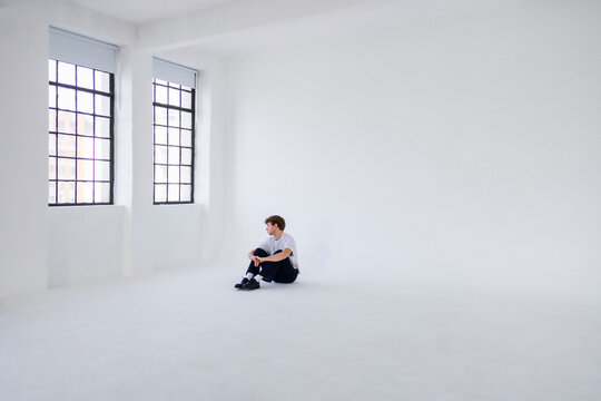 Man Sitting Alone In Bright White Studio