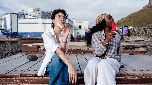 Women friends enjoying popsicles during summer vacation