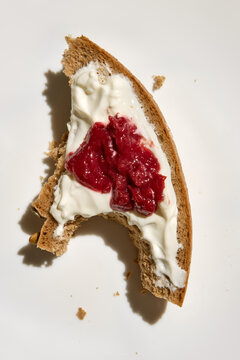 Close up of a Piece of Bread With Cream and Jam on a White Plate 