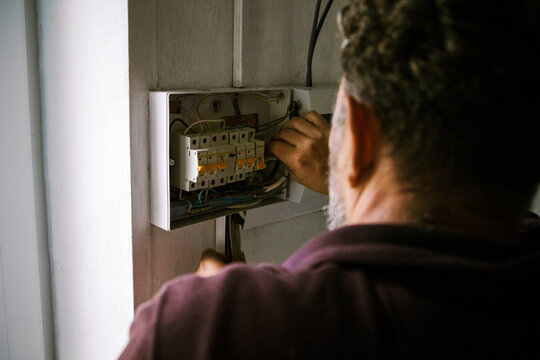 Electrician works on circuit breaker panel