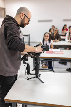 Teacher preparing camera with gimbal in classroom