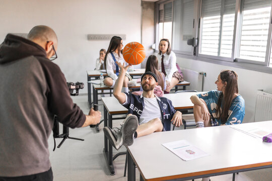 Teacher filming students inside a classroom at a high school