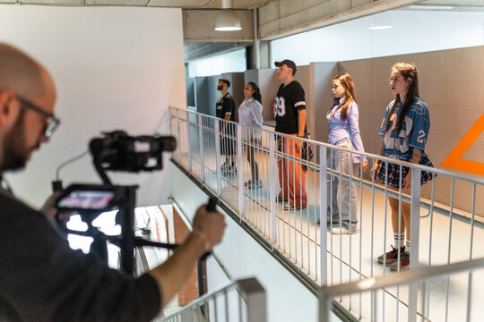 Teacher filming students dancing in school hallway