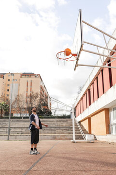Student scoring a basketball shot in school playground