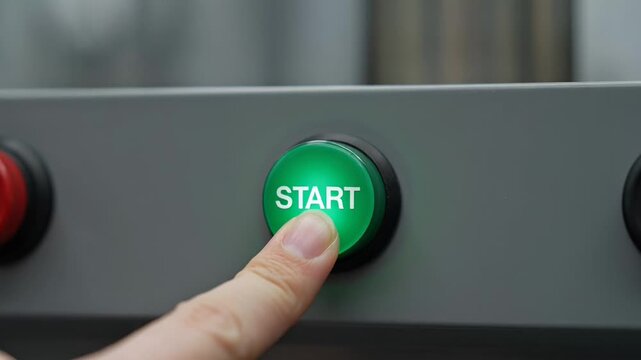 ?Pressing a start button to activate machinery in closeup sequence