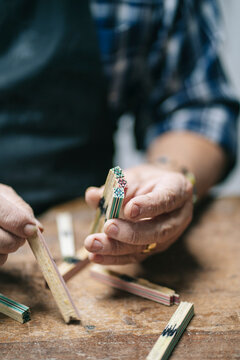 Luthier hands crafting wooden inlay for guitar rosette