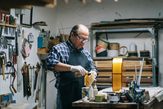 Luthier crafting a musical instrument in his workshop