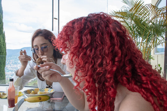 Family Enjoy Food at a Dining Table With a City View