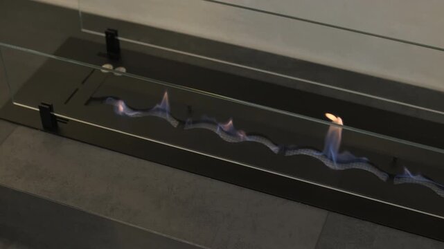 Modern minimalist living room with linear bio fireplace and white boucle armchai